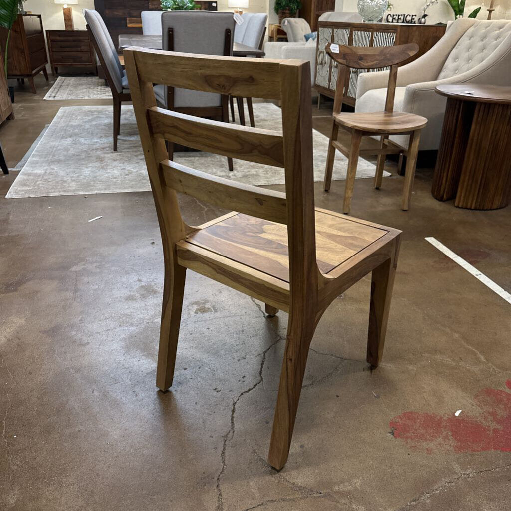 Wooden chair in a showroom setting with other furniture in the background