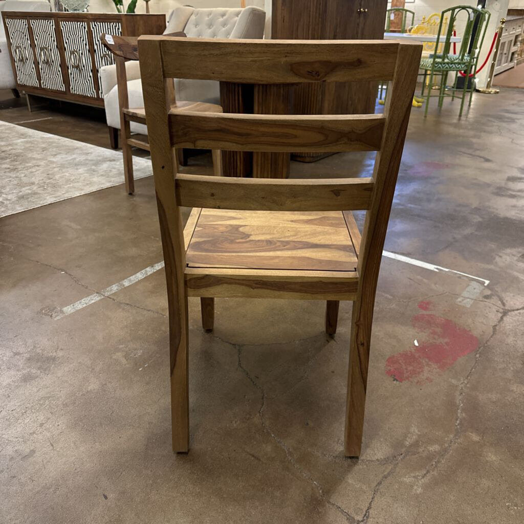 Wooden chair in a showroom setting with other furniture in the background