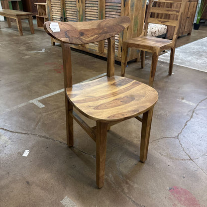 Wooden chair with a rustic finish on a concrete floor