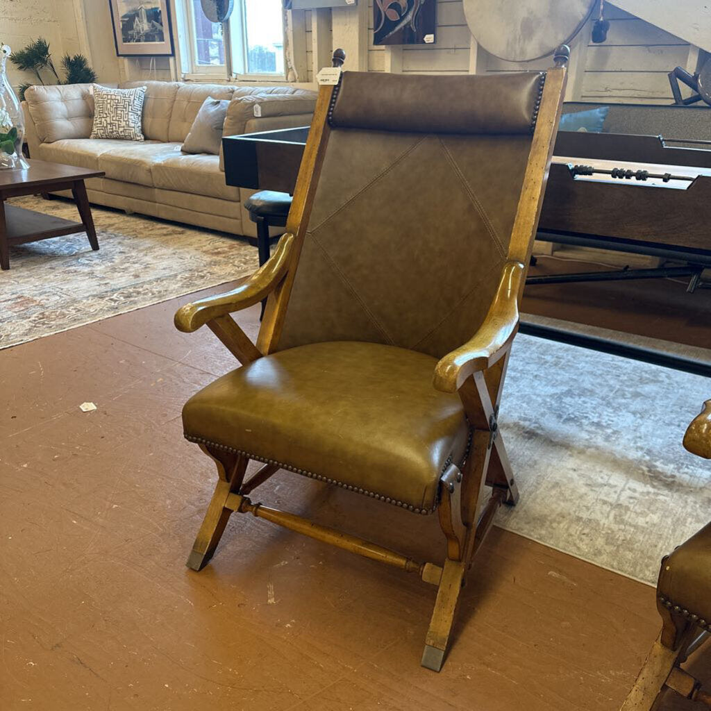 Brown leather armchair in a living room setting with a couch and coffee table.