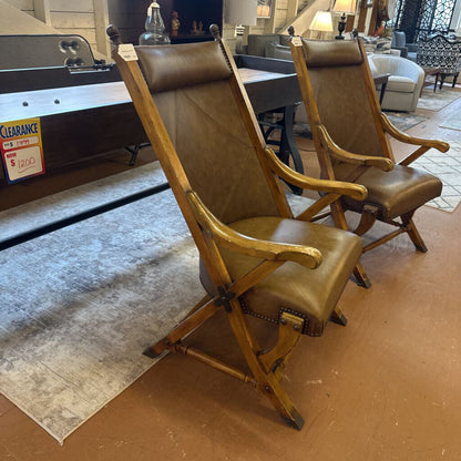 Two brown folding chairs on a wooden floor with a blurred background of a store interior.