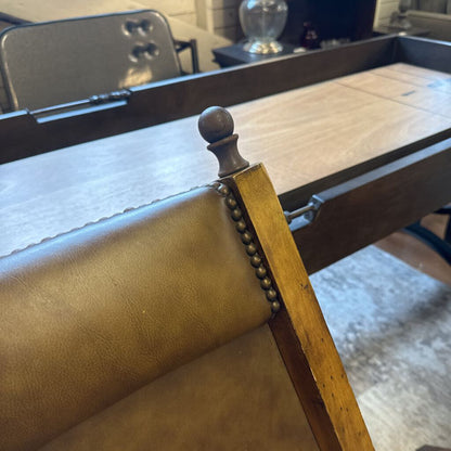 Close-up of a wooden chair with leather seat and backrest in an indoor setting.