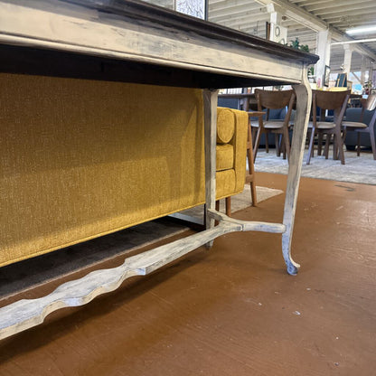 Wooden table with a yellow cushion on a wooden floor in an indoor setting