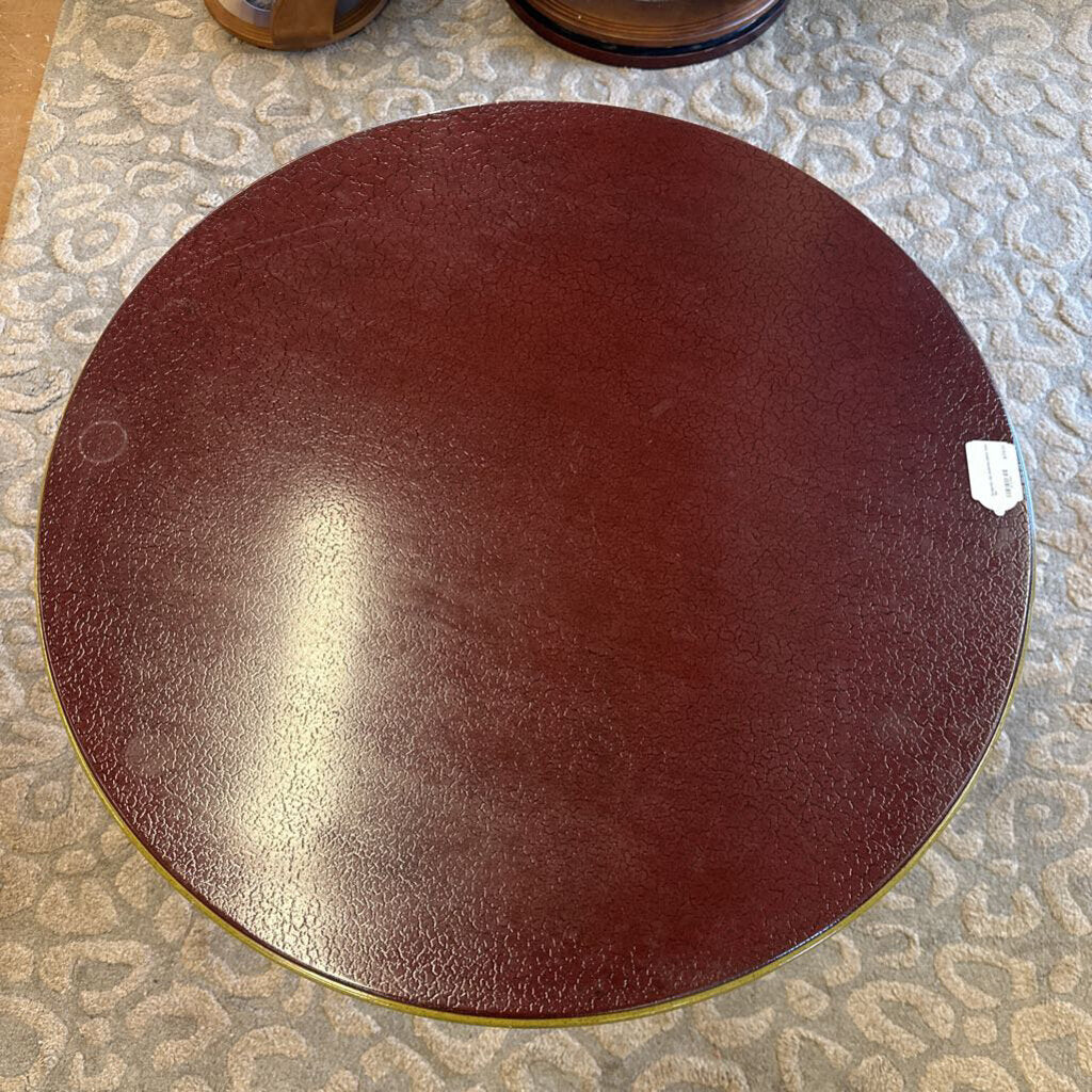 Round brown leather ottoman on a patterned floor