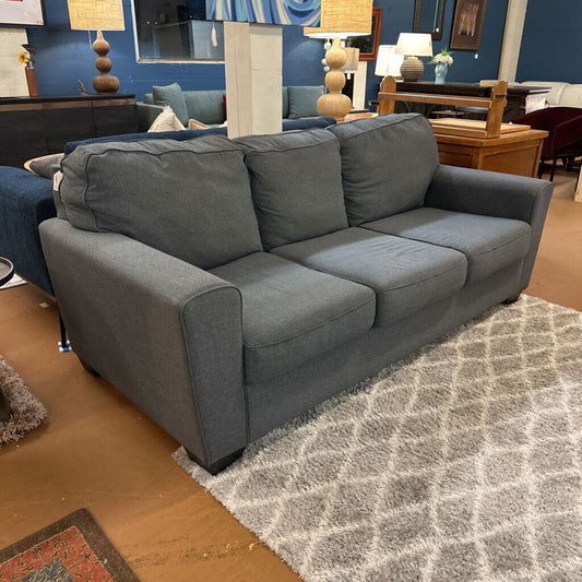 Gray sofa in a room with furniture and decor