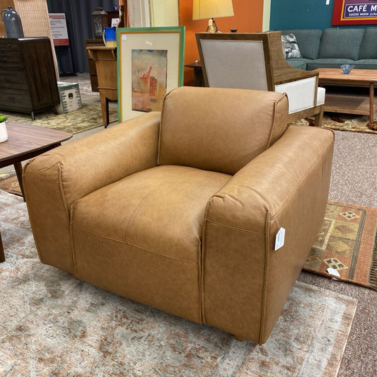 Brown armchair in a furniture store setting with other items in the background