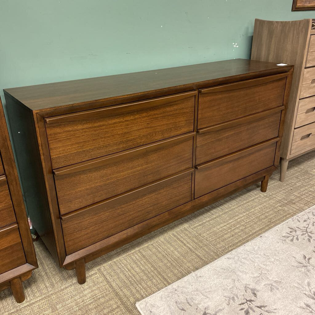 Wooden dresser with multiple drawers in a room setting.