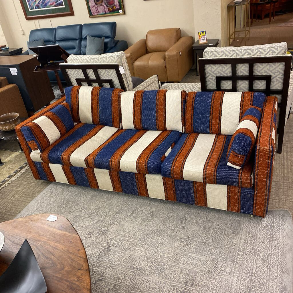 Multicolored striped sofa in a room with other furniture.