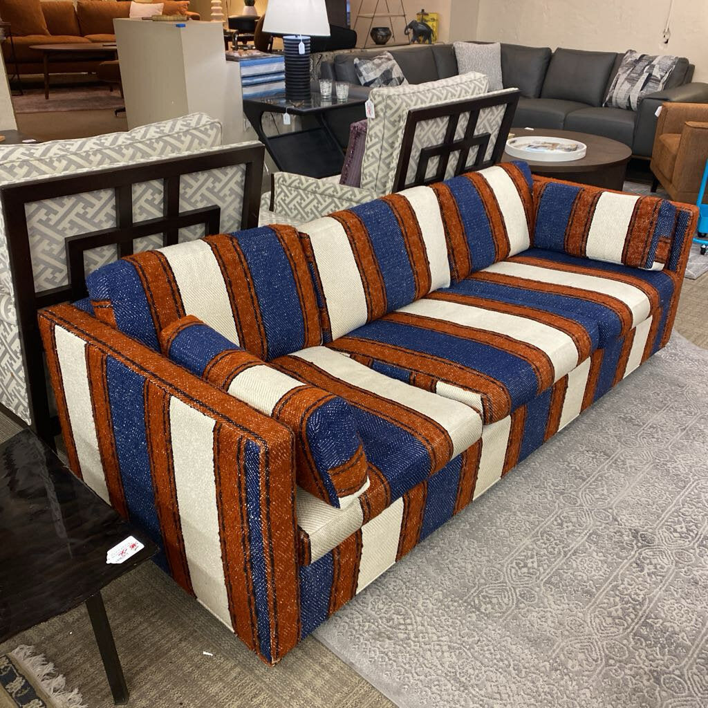 Striped sofa with blue, brown, and white pattern in a room setting.