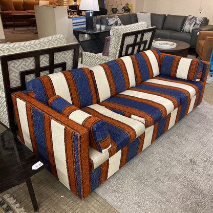Striped sofa with blue, brown, and white pattern in a room setting.