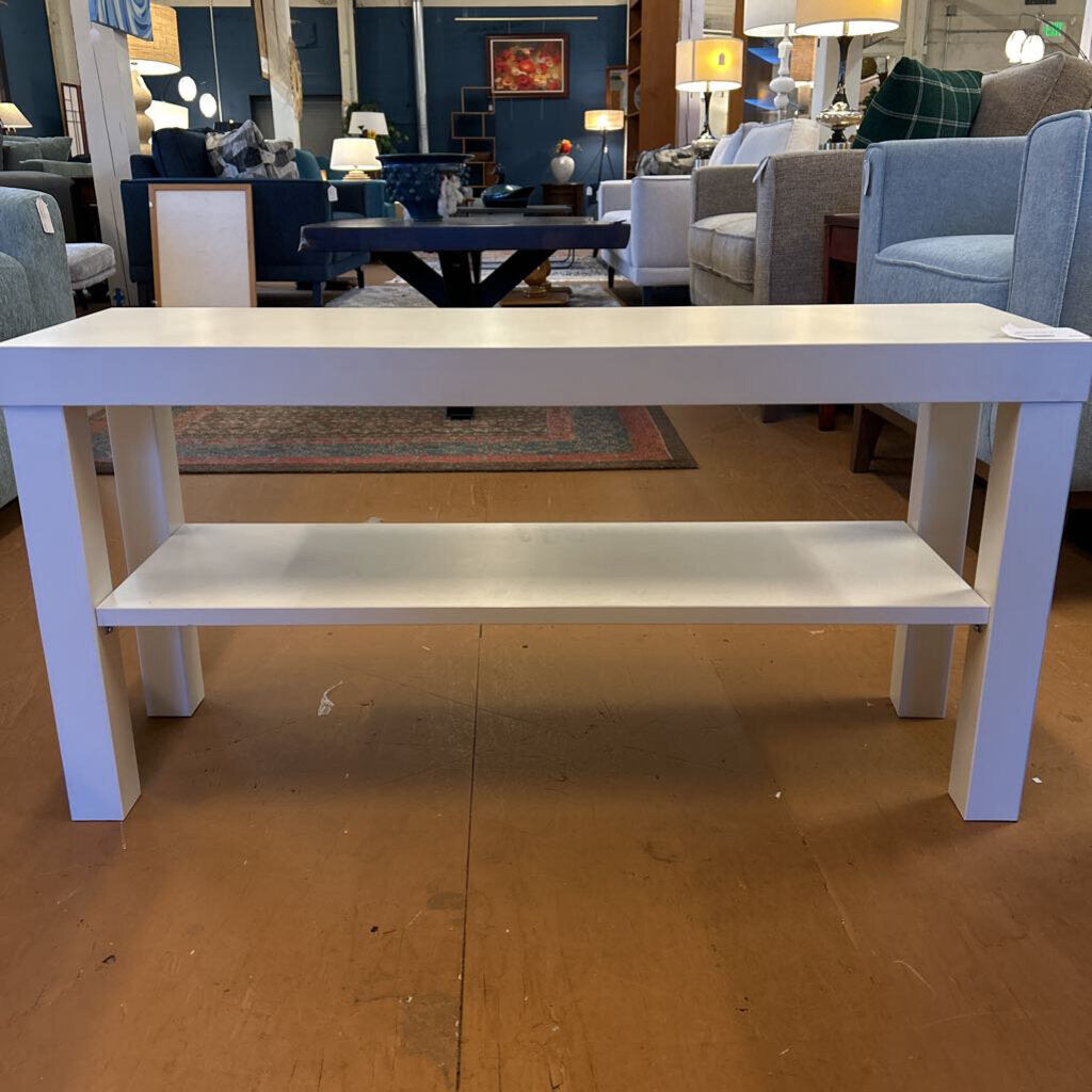 White table with a shelf in a furniture store setting