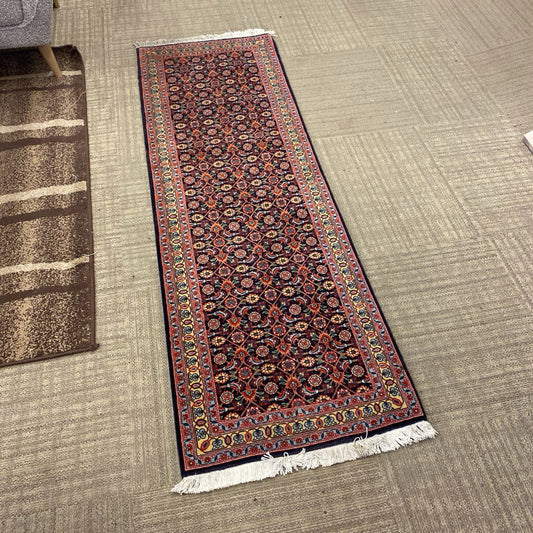 Decorative runner rug with intricate patterns on a carpeted floor