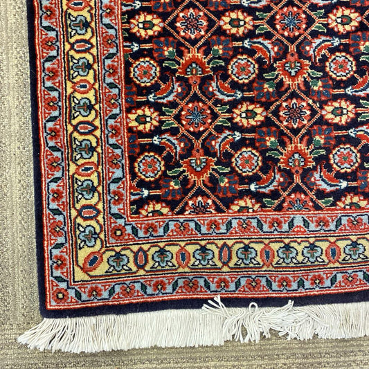 Close-up of a colorful patterned rug with intricate designs and white tassels.