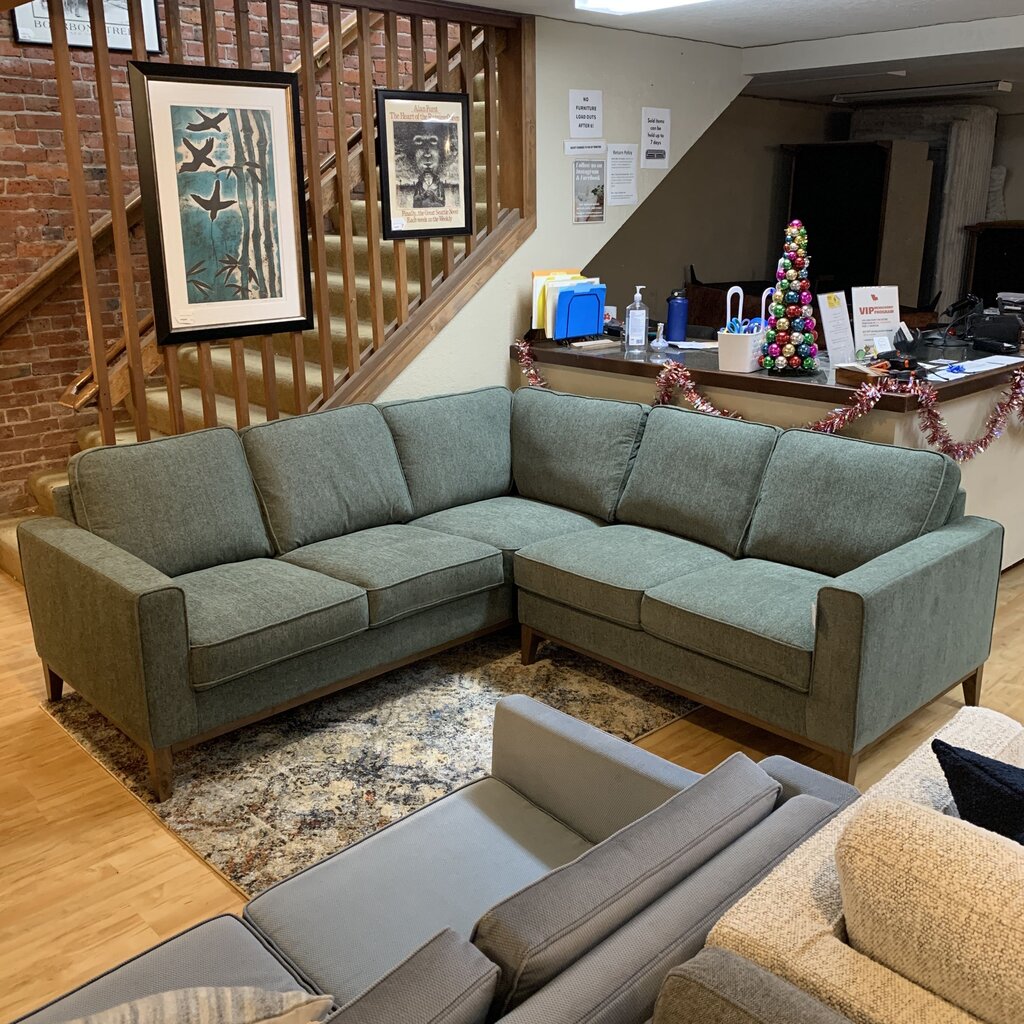Sectional sofa in a living room with decorative elements and framed artwork on the wall.
