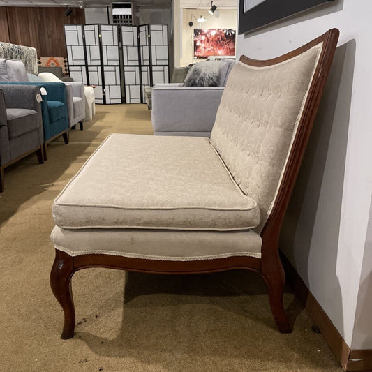 Ornate armless settee in cream damask fabric with button tufting and cabriole legs.