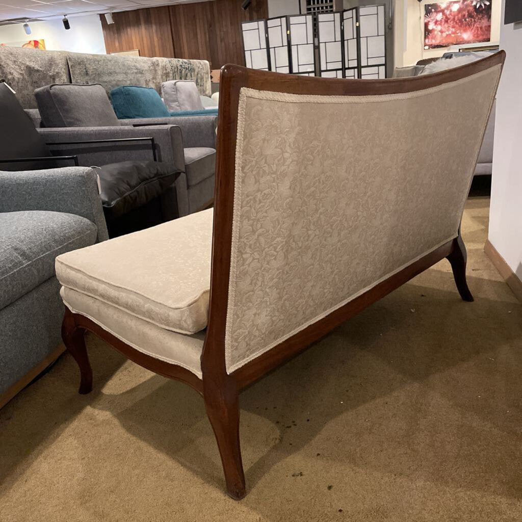 Ornate armless settee in cream damask fabric with button tufting and cabriole legs.