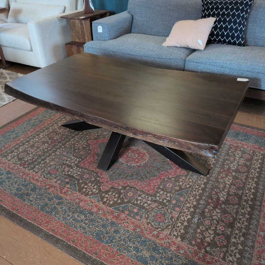 Wooden coffee table in a living room setting with a sofa and rug.
