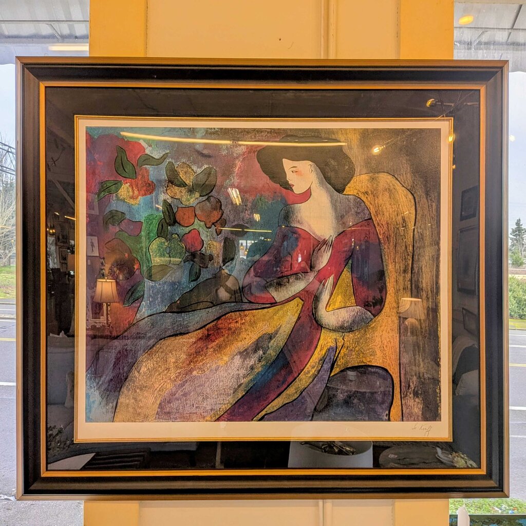 Framed artwork of a woman in a colorful dress with flowers in a room setting.