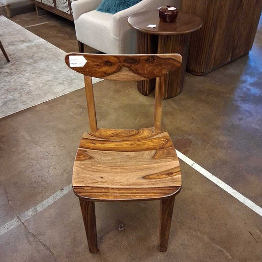 Wooden chair with a unique design on a stone floor