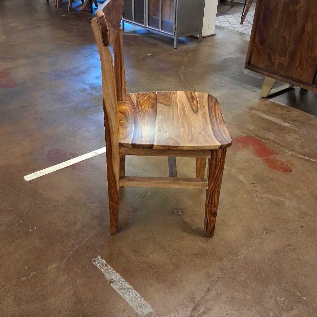 Wooden chair on a concrete floor with a blurred background