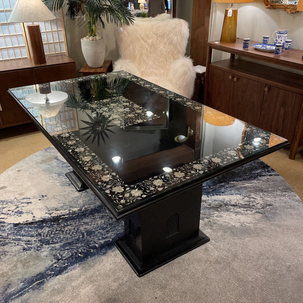 Decorative black table with floral patterns on a rug in a room setting