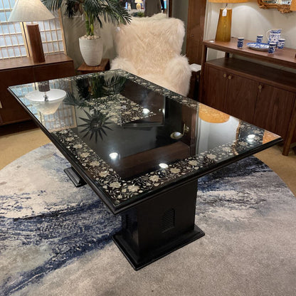 Decorative black table with floral patterns on a rug in a room setting