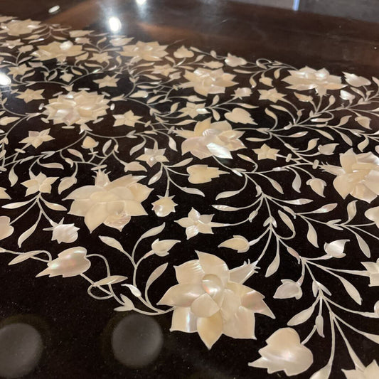 Decorative surface with white floral patterns on a dark background