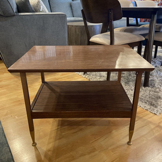 Wooden side table on a wooden floor with a blurred background
