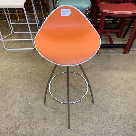 Orange bar stool with metal base on a concrete floor