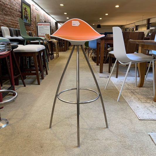 Bar stool with orange seat and metal legs in a restaurant setting
