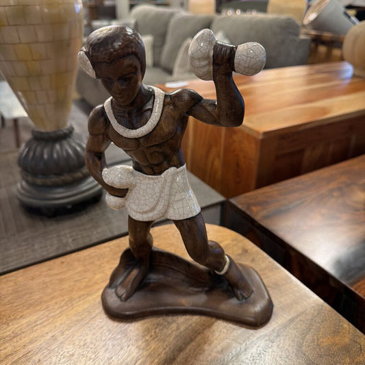 Wooden figurine of a boxer on a wooden surface with a blurred background
