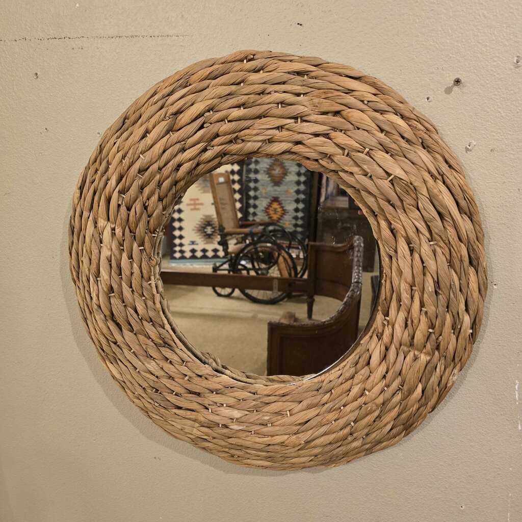 Round woven mirror on a beige wall