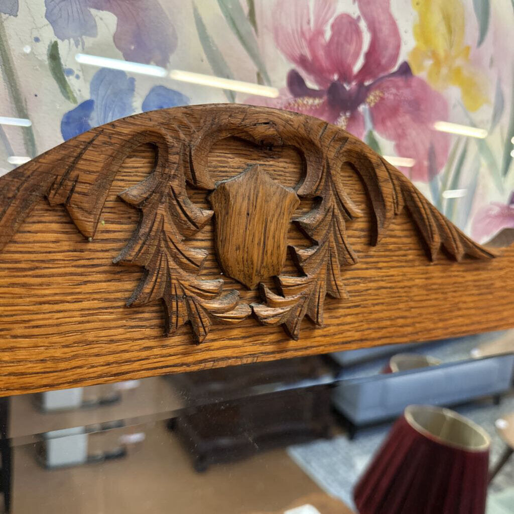 Wooden decorative panel with intricate carvings in a blurred indoor setting