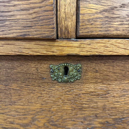 Close-up of a wooden drawer with an ornate metal handle.