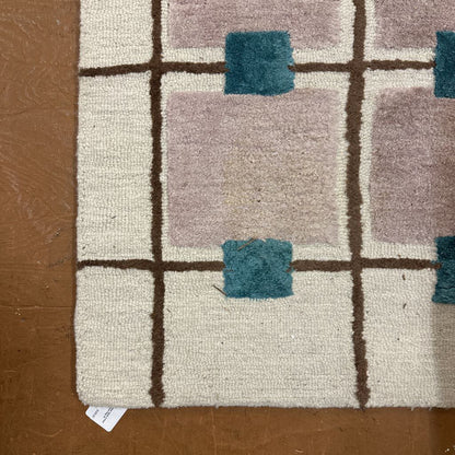 Close-up of a textured rug with geometric pattern on a brown surface