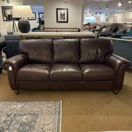a dark brown leather 3 seat sofa with rolled arms and wooden legs