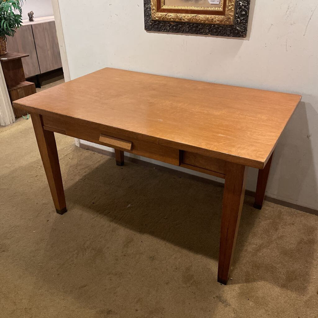 Wooden table in a room with a painting on the wall
