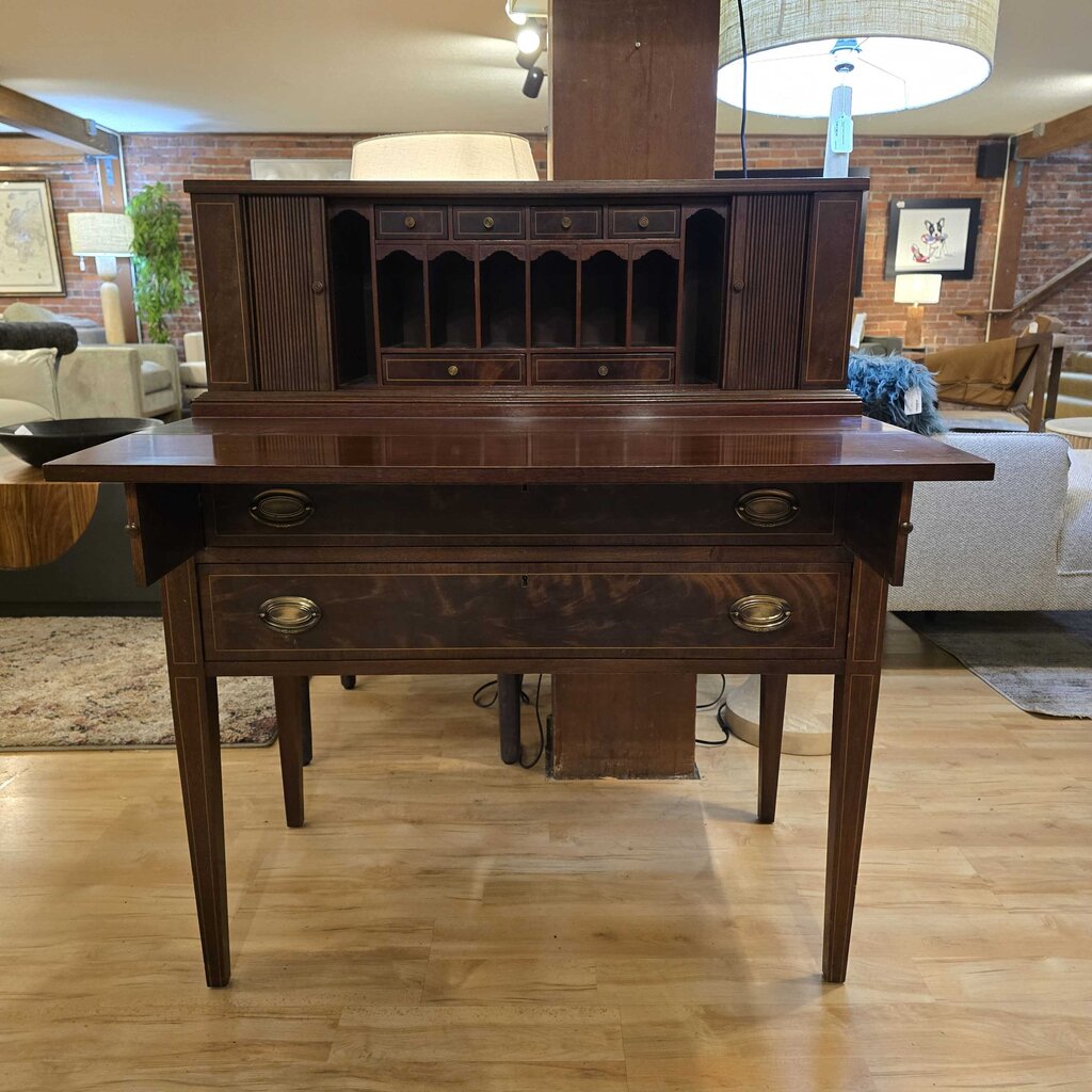 Wooden desk in a living room setting with furniture and decor in the background