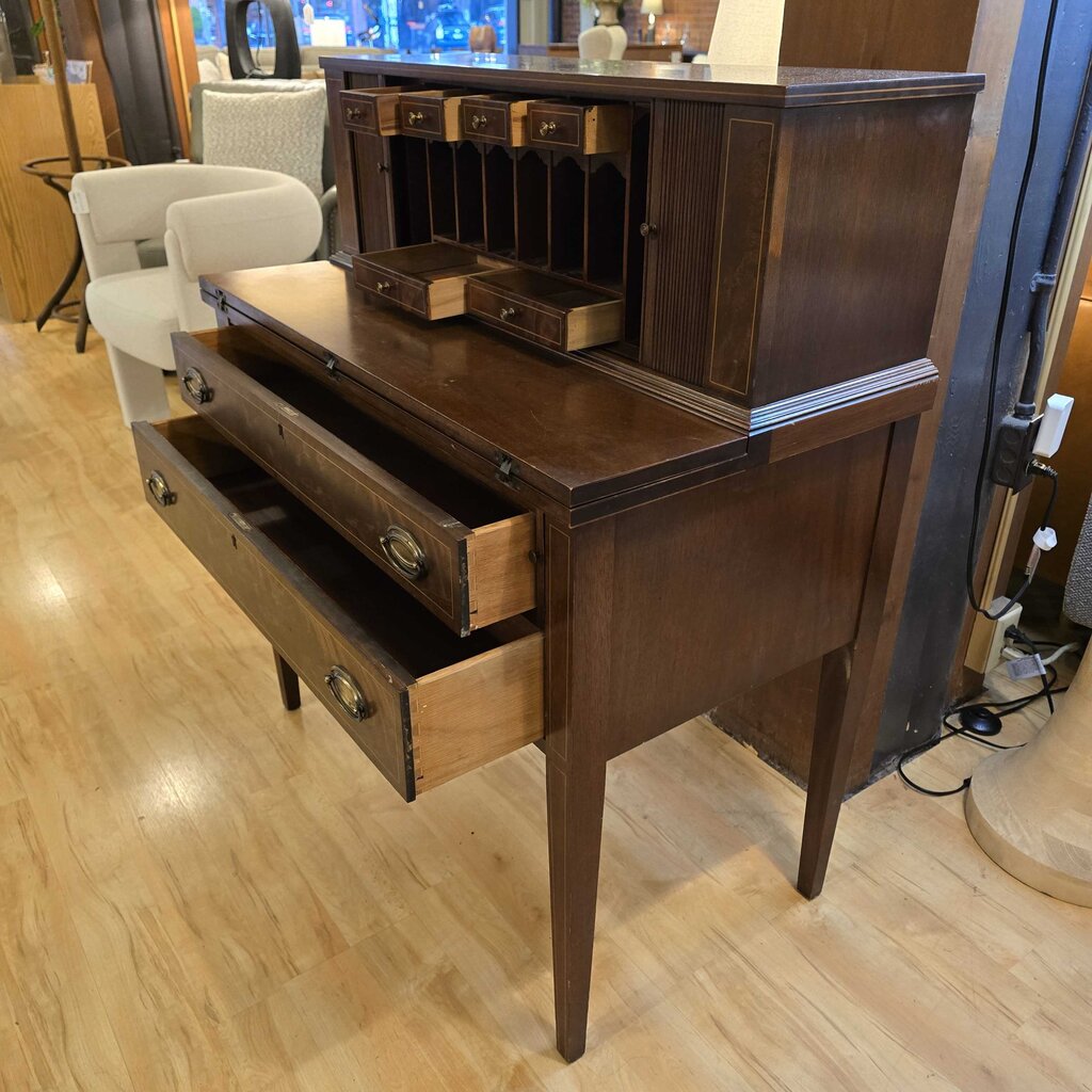 Wooden desk with open drawers on a wooden floor