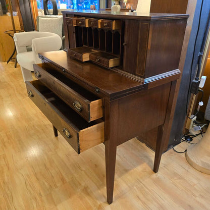 Wooden desk with open drawers on a wooden floor