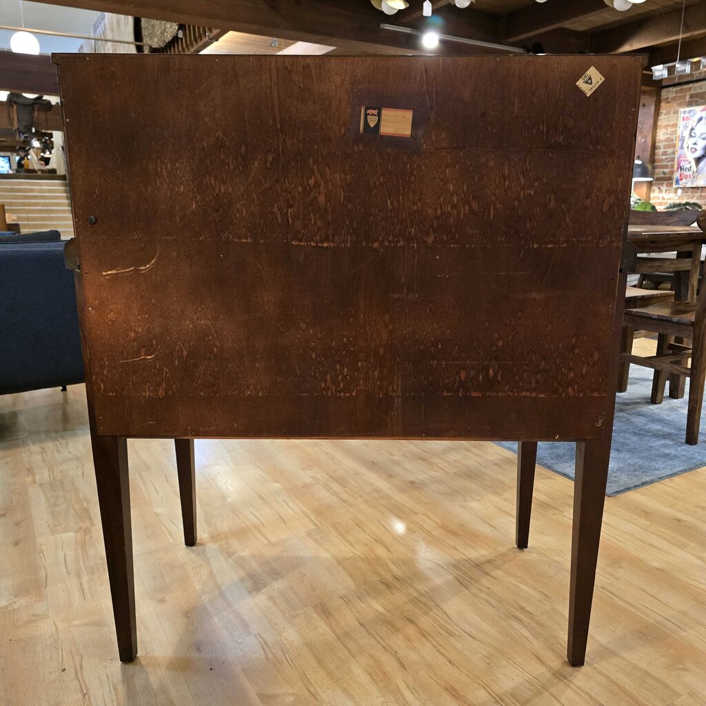 Brown wooden table with a checkered floor and blurred background