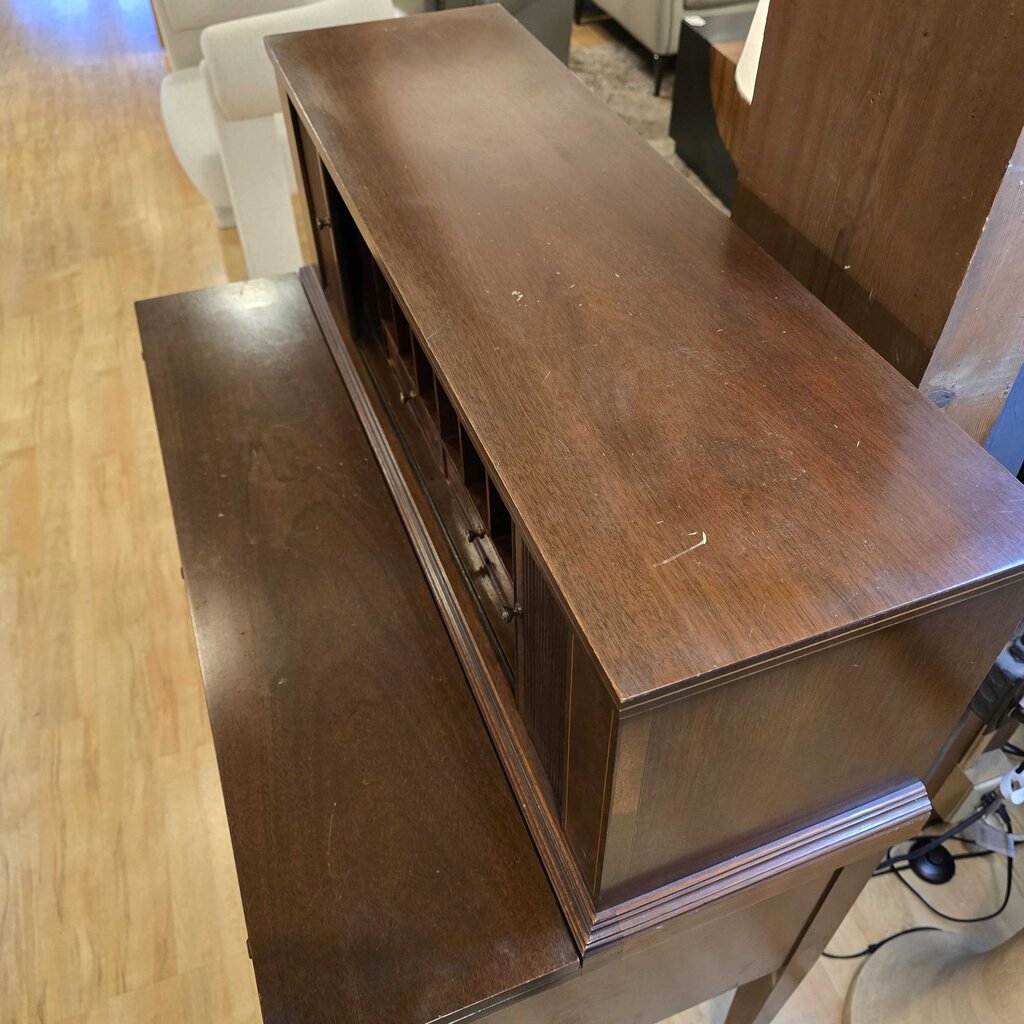 Wooden entertainment console with open door on a wooden floor