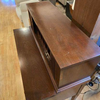 Wooden entertainment console with open door on a wooden floor