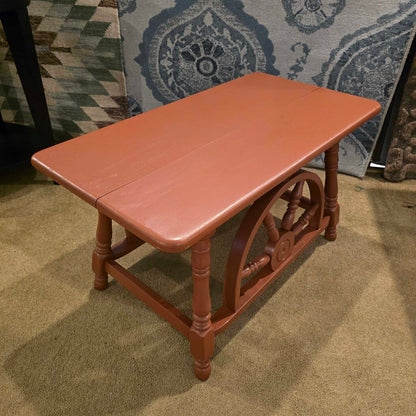 Wooden table with decorative legs on a carpeted floor