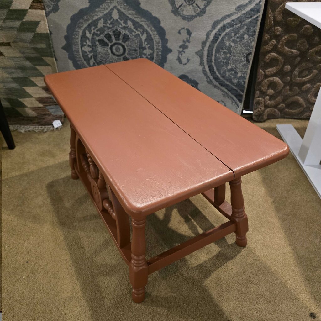 Wooden bench with a patterned rug in the background