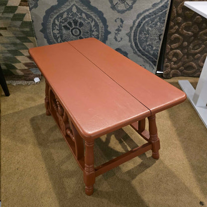 Wooden bench with a patterned rug in the background