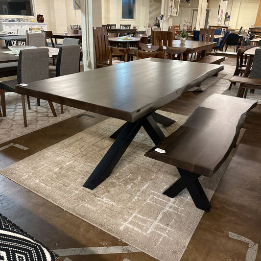 Wooden dining table with benches in a showroom setting