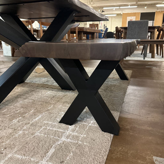 Dining table with X-shaped black legs in a showroom setting