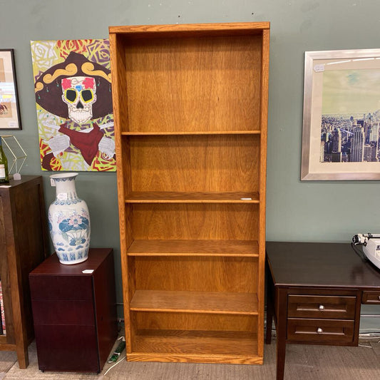 Wooden bookshelf in a room with furniture and decor