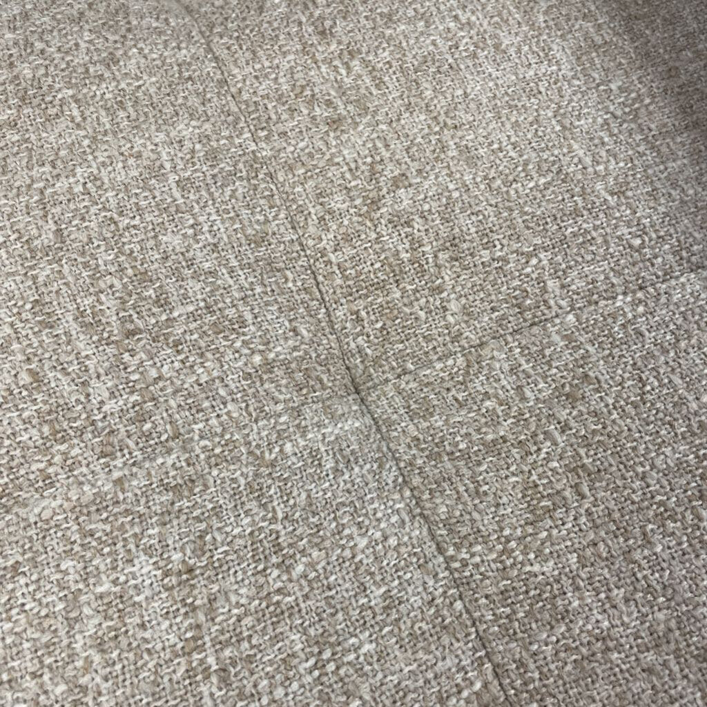 Close-up of textured beige fabric with a subtle pattern